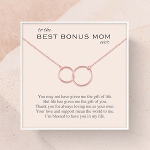 May include: A rose gold necklace with two interlocking circles, presented in a white box with a card that reads "to the BEST BONUS MOM ever". You may not have given me the gift of life. But life has given me the gift of you. Thank you for always loving me as your own. Your love and support mean the world to me. I'm blessed to have you in my life.