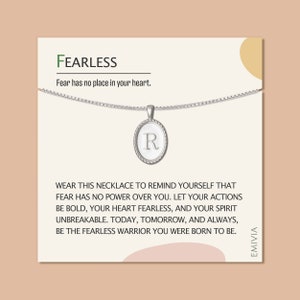May include: Silver necklace with a pendant featuring the letter R. The necklace comes with a card that reads "FEARLESS. Fear has no place in your heart. Wear this necklace to remind yourself that fear has no power over you. Let your actions be bold, your heart fearless, and your spirit unbreakable. Today, tomorrow, and always, be the fearless warrior you were born to be."