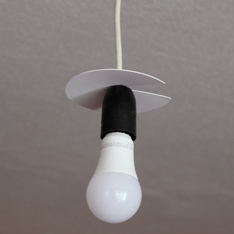 May include: A white ceiling light fitting with a white cord and a white plastic canopy. A white LED light bulb is attached to the fitting.