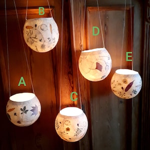 Tissue paper lantern with pressed flowers and plants. Window decoration, patio lighting, balcony lighting