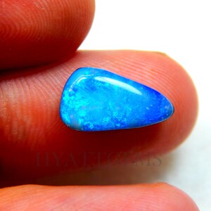 May include: A blue and green opal gemstone with a teardrop shape. The opal is set against a white background.