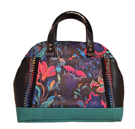 Wild backlit-garden faux-leather purse with Sassafras zippers — looks like wearable psychedelic folk art, not a factory bag.