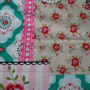 Pode incluir: Um tecido patchwork com uma variedade de padrões florais em tons de rosa, azul e verde. O tecido apresenta um padrão repetitivo de rosas e outras flores, bem como um padrão xadrez preto e branco.