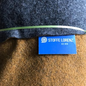 Könnte beinhalten: Nahaufnahme eines braunen Stoffes mit einem blauen Etikett mit der Aufschrift "Stoffe Lorenz Est. 1978".