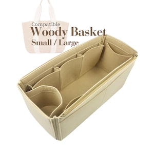 Puede incluir: Organizador de bolso de fieltro beige con múltiples compartimentos y una cremallera dorada. El organizador está diseñado para encajar dentro de un Woody Basket, con el texto "Compatible Woody Basket Small / Large".