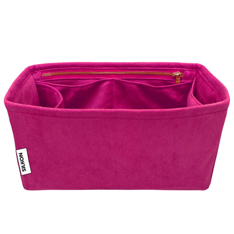 May include: A fuchsia-colored handbag organizer with multiple compartments and a zippered top closure. The organizer is made of a soft, felt-like material and features the brand name "SILKON" on a white tag.