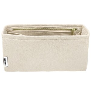 May include: Beige rectangular bag organizer with a zippered top and multiple compartments. The bag is made of a soft, textured material and features a gold-colored zipper. The brand name "SILKON" is printed on a small label on the side.