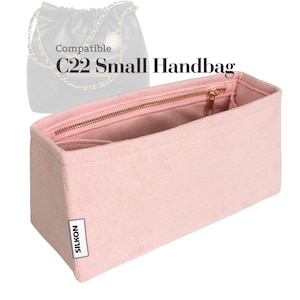 May include: A pale pink handbag organiser with a gold zip and several compartments. The text "Compatible C22 Small Handbag" is displayed above the organiser. The brand name "SILKON" is printed on a white label.