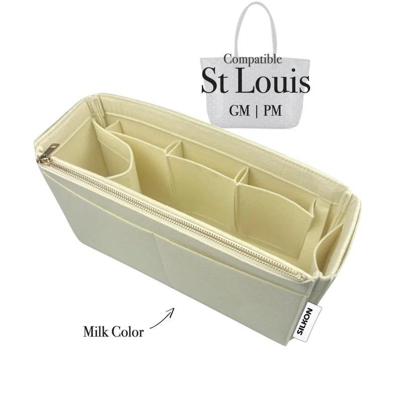 May include: A milk-colored felt bag organizer with multiple compartments and a zippered closure. The organizer is designed to fit the St Louis GM and PM tote bags. The text "Compatible St Louis GM | PM" is visible in the image.