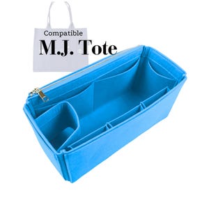 Puede incluir: Organizador de bolso tote azul brillante con múltiples compartimentos y una cremallera dorada. El organizador está diseñado para caber dentro de un bolso tote. El texto "Compatible M.J. Tote" es visible.
