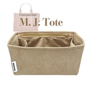Könnte beinhalten: Beige Tote-Taschen-Organizer mit mehreren Fächern und einem Reißverschluss oben. Der Organizer ist für die Innenseite einer M.J. Tote-Tasche konzipiert. Das Wort "Compatible" steht über den Worten "M.J. Tote". Der Markenname "SILKON" steht auf einem weißen Etikett.