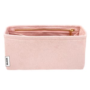 May include: A light pink handbag organizer with a zippered compartment and multiple pockets. The organizer has a rectangular shape and a gold-colored zipper. The brand name "SILKON" is printed on a white label on the side.