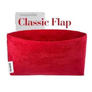 Könnte beinhalten: Ein leuchtend roter Taschenorganizer mit dem Text "Compatible Classic Flap". Der Organizer besteht aus einem weichen, samtigen Material und hat eine rechteckige Form. Ein weißes Etikett mit dem Markennamen "SILKON" ist sichtbar.