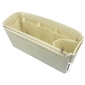 May include: Cream-colored felt bag organizer with multiple compartments and a zippered closure. The organizer has various pockets and sections for storing items. The "SILKON" brand label is visible on the side.