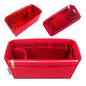 May include: Red felt handbag organizer with multiple compartments and a gold zipper. The organizer has a rectangular shape and is designed to fit inside a larger bag. The brand name "SILKON" is visible on a small white tag.