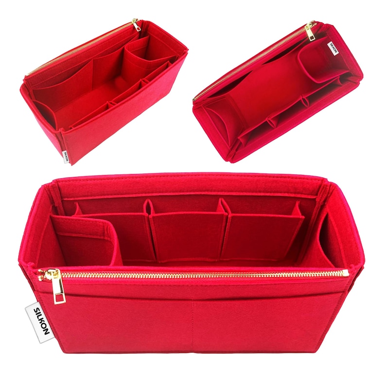May include: Red felt handbag organizer with multiple compartments and a gold zipper. The organizer has a rectangular shape and is designed to fit inside a larger bag. The brand name "SILKON" is visible on a small white tag.