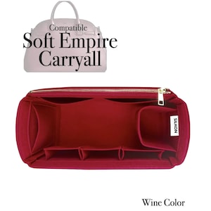 Könnte beinhalten: Ein weinroter Handtaschen-Organizer mit mehreren Fächern und einem goldenen Reißverschluss. Der Text "Compatible Soft Empire Carryall" befindet sich über dem Organizer. Das Wort "SILKON" steht auf einem weißen Etikett. Die Worte "Wine Color" stehen unten.