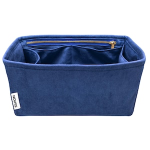 May include: A navy blue bag organizer with multiple compartments and a zippered top closure. The interior features several pockets for organization. The bag has a rectangular shape and a label that reads "SILKON".