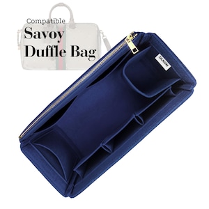 Puede incluir: Un organizador de bolso azul marino con múltiples compartimentos y una cremallera dorada. El texto "Compatible Savoy Duffle Bag" se muestra encima del organizador. La marca "SILKON" es visible en una pequeña etiqueta blanca.