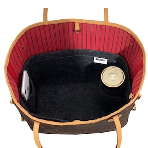 May include: A brown and tan tote bag with a red striped interior. Inside, a black felt organiser holds a phone and a compact. The organiser has a "SILKON" tag.
