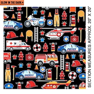 Könnte beinhalten: Ein schwarzer Stoff mit einem sich wiederholenden Muster aus Einsatzfahrzeugen, darunter Polizeiautos, Feuerwehrautos, Krankenwagen und ein Hubschrauber. Das Muster enthält auch Feuerhydranten, Leitern, Erste-Hilfe-Kästen und andere Notfallartikel. Der Stoff leuchtet im Dunkeln. Der Stoff misst etwa 50 cm x 50 cm.