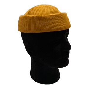 May include: A mustard yellow beanie with a ribbed texture.