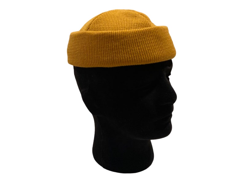 May include: A mustard yellow beanie with a ribbed texture.