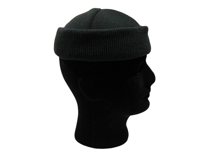 May include: A dark green beanie with a ribbed texture. The beanie is folded up at the top, creating a rounded shape.