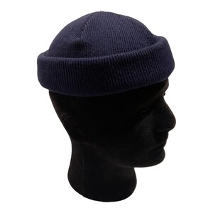 May include: A navy blue beanie with a folded brim. The beanie is made of a soft, knitted fabric.
