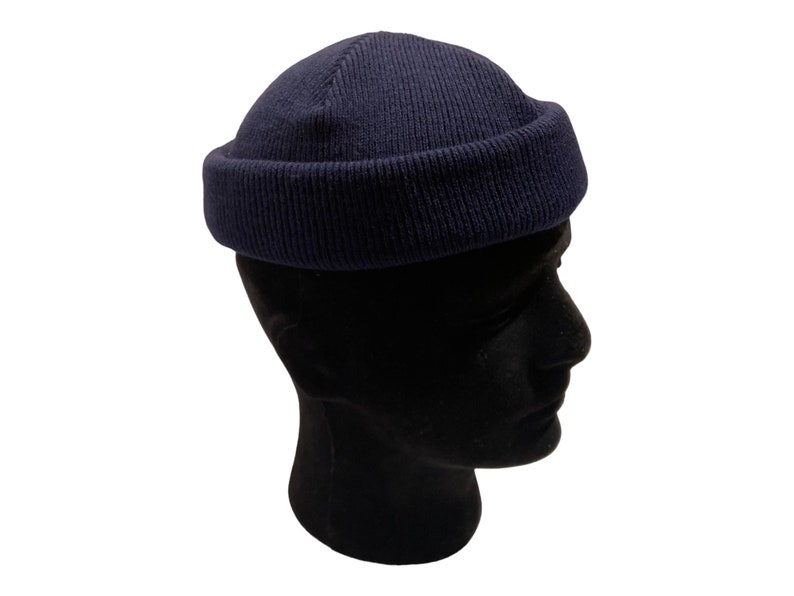 May include: A navy blue beanie with a folded brim. The beanie is made of a soft, knitted fabric.