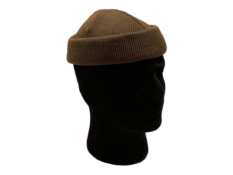 May include: A brown knitted beanie with a rounded crown and a folded brim.