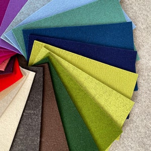 May include: A fan-shaped arrangement of felt fabric swatches in various colors, including red, purple, blue, green, brown, and beige.