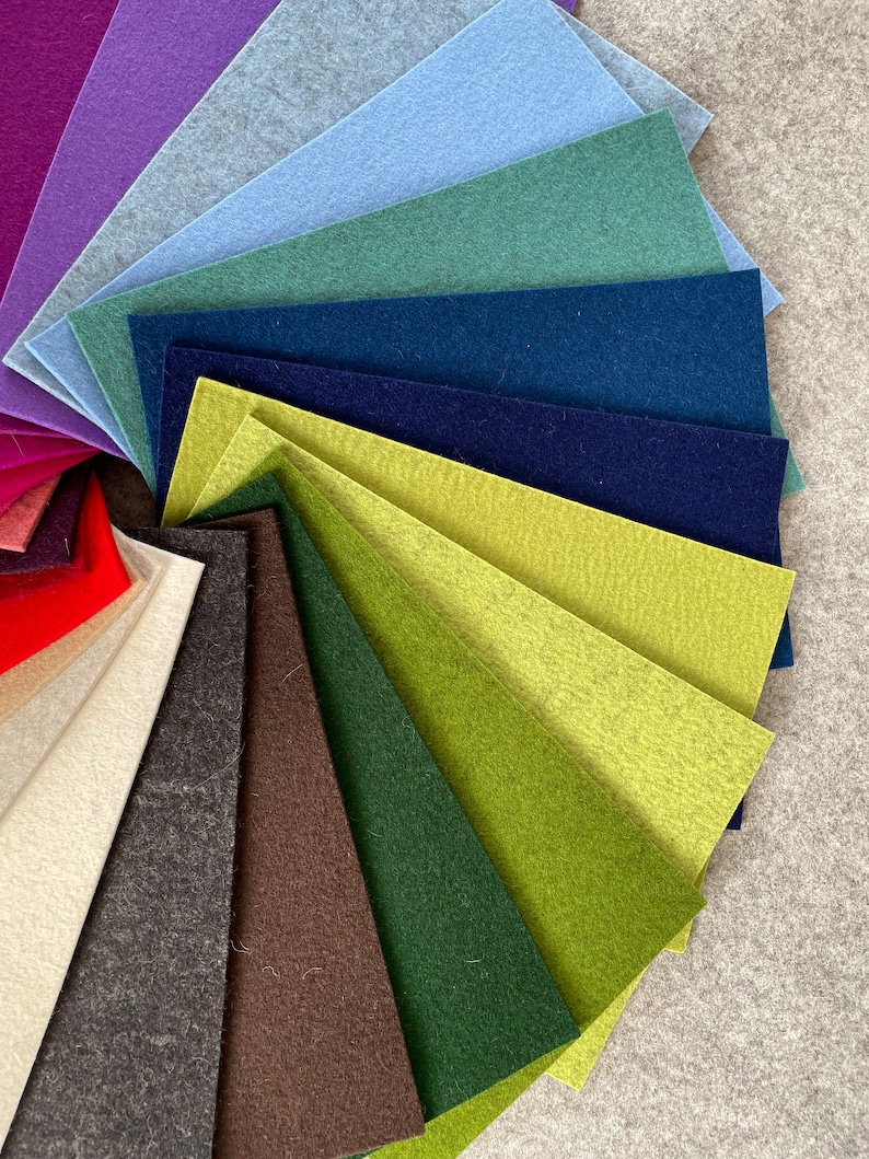 May include: A fan-shaped arrangement of felt fabric swatches in various colors, including red, purple, blue, green, brown, and beige.