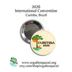 May include: A round button with a pin back, featuring the text "CURITIBA 2026" and an illustration of a tree, a fox, and a sun. The button also includes the text "2026 International Convention Curitiba, Brazil".