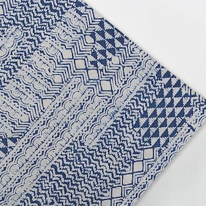 Może przedstawiać: Zbliżenie na niebiesko-białą tkaninę z geometrycznym wzorem. Tkanina jest wykonana z bawełny i idealnie nadaje się do patchworku, szycia lub rękodzieła.