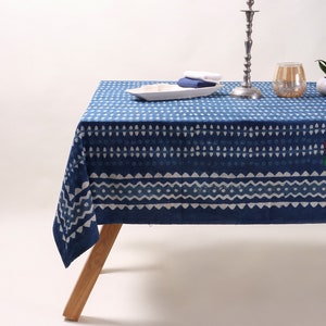 Peut inclure: Une nappe à motifs bleus et blancs avec un design géométrique. La nappe est en coton et est parfaite pour une table à manger.