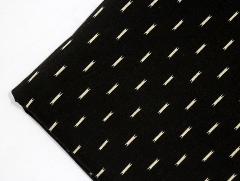 May include: Black fabric with a white, repeating pattern of small, diagonal lines.