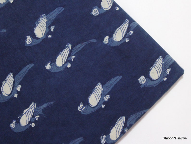K&ouml;nnte beinhalten: Indigo blauer Baumwollstoff mit einem wei&szlig;en Vogelmuster. Der Stoff ist ein traditionelles indisches Handblockdruckdesign.