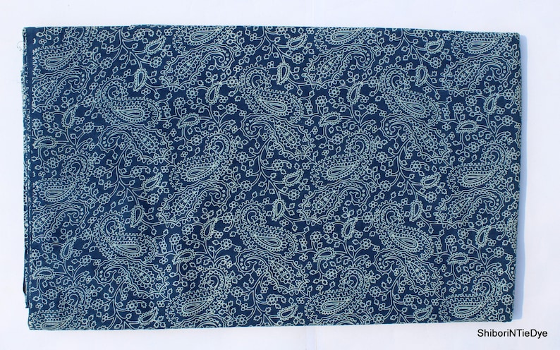 May include: A dark blue fabric with a white paisley pattern. The fabric is soft and has a subtle sheen.