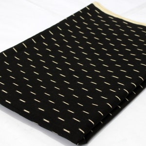 May include: Black fabric with a white dotted pattern. The fabric is folded in half and the edges are visible.