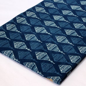 May include: Blue cotton fabric with a white diamond pattern. The diamonds have a geometric design inside.