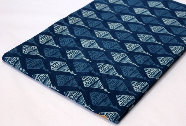 May include: Blue cotton fabric with a white diamond pattern. The diamonds have a geometric design inside.