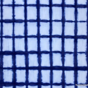 Könnte beinhalten: Ein blauer und weißer Batikstoff mit einem Gittermuster. Der Stoff ist mit einer Shibori-Technik hergestellt, einer traditionellen japanischen Färbemethode.