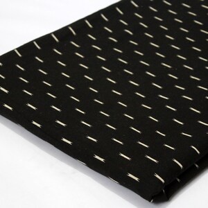 May include: Black fabric with a white, diagonal, repeating pattern of thin lines.