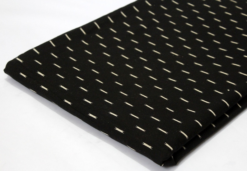 May include: Black fabric with a white, diagonal, repeating pattern of thin lines.