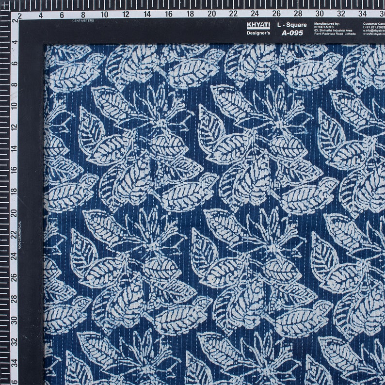 May include: Blue cotton fabric with a white leaf pattern. The fabric has a subtle texture and is perfect for quilting or other craft projects.