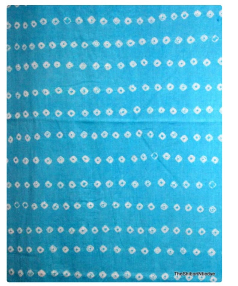 May include: A blue fabric with a white diamond pattern. The fabric is a shibori tie-dye pattern.