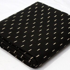 May include: Black fabric with a white geometric pattern. The fabric is folded in half and the pattern is visible on both sides.