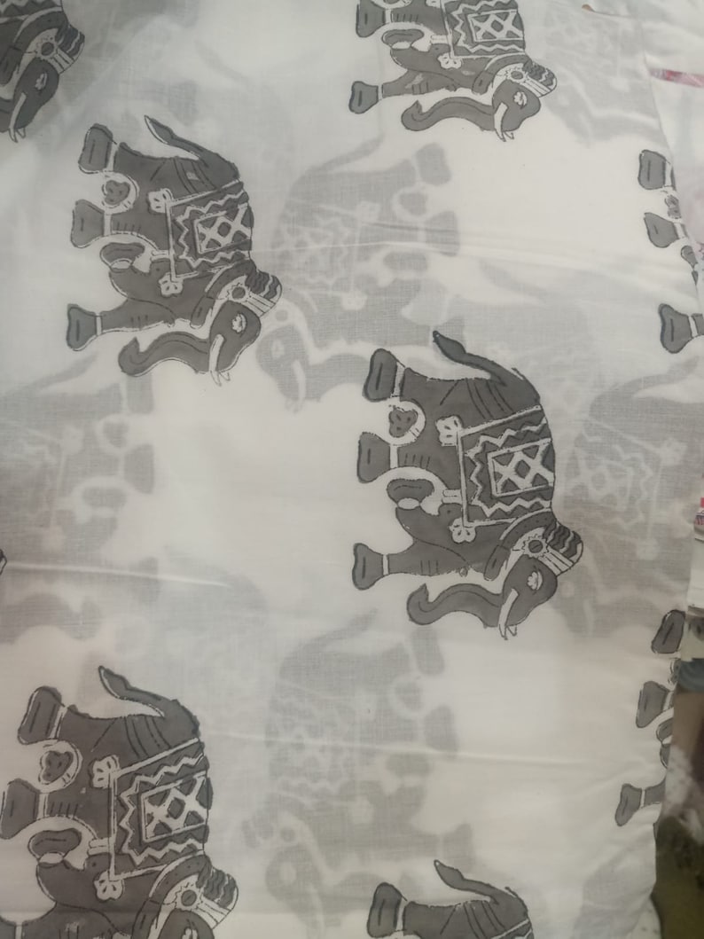 May include: White fabric with a repeating pattern of gray elephants. The elephants are stylized and have intricate designs on their bodies.