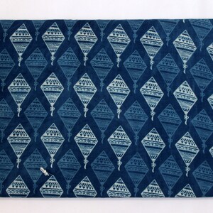 May include: A blue fabric with a white patterned design of kites. The fabric has a subtle texture and a slightly faded look.